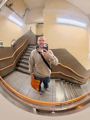 Station mirror selfie of me wearing mid-blue jeans and a grey hoodie