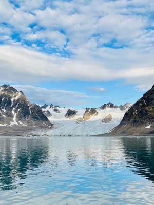 A glacier entering the sea between pointy mountains