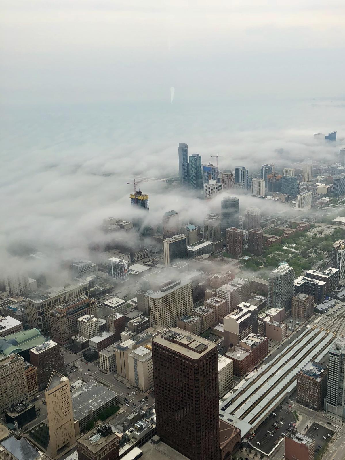 Tall buildings sticking up through low clouds