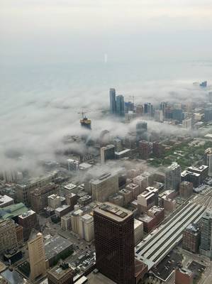 Tall buildings sticking up through low clouds